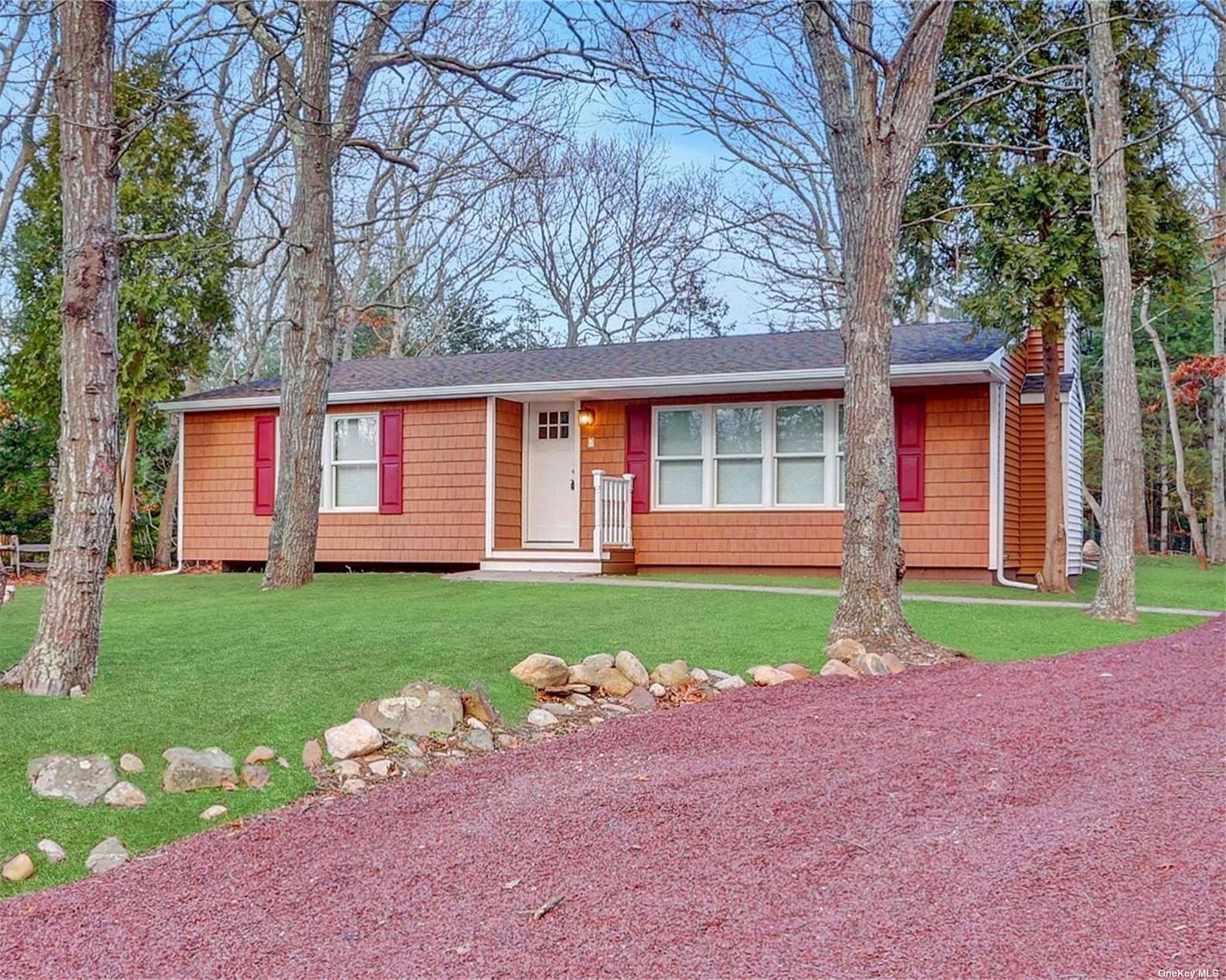 a view of a house with a yard and large tree