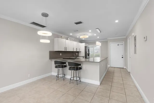 a kitchen with stainless steel appliances granite countertop a sink and cabinets with wooden floor