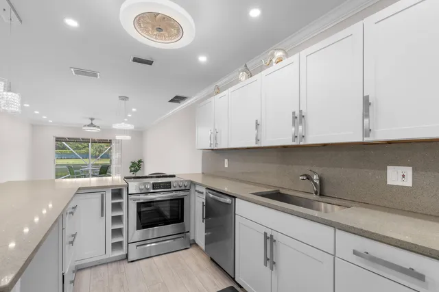 a kitchen with a white stove refrigerator and cabinets with wooden floor