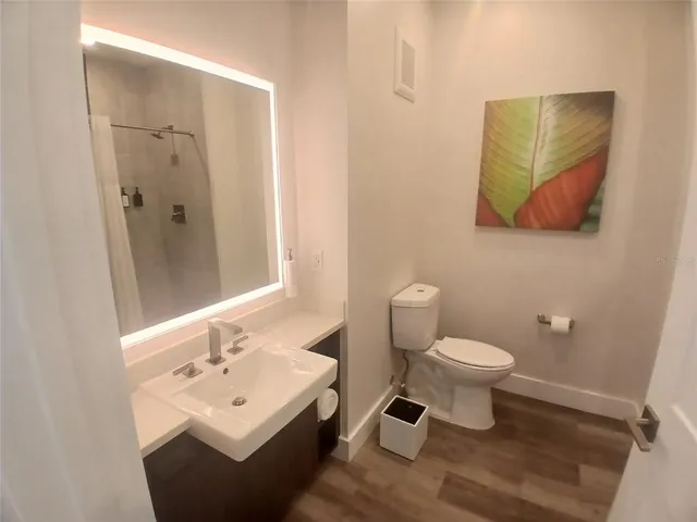 a kitchen with stainless steel appliances granite countertop a sink dishwasher a stove a refrigerator and a dining table with wooden floor