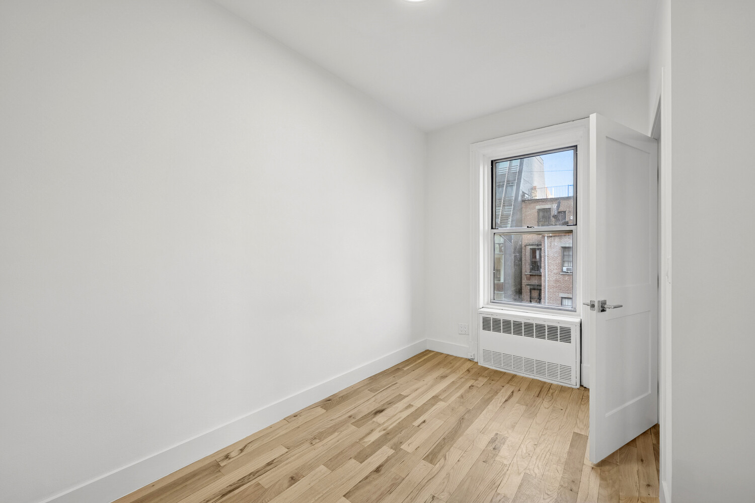 145 West 80th Street, Unit 4R Manhattan, NY 10024 - Photo 10 of 16 an empty room with wooden floor and windows