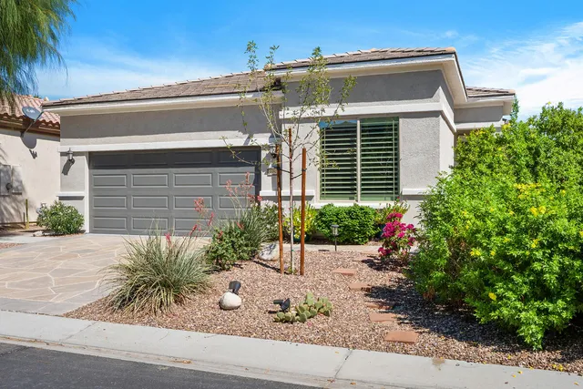 a front view of a house with plants