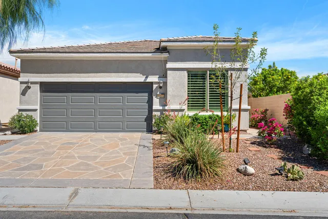 a front view of a house with plants