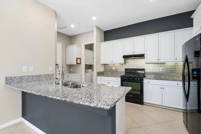 a kitchen with stainless steel appliances granite countertop a sink dishwasher stove and refrigerator