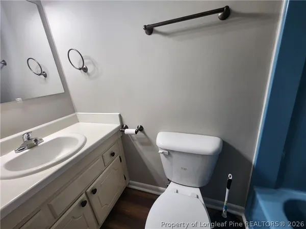 a bathroom with a granite countertop toilet sink and mirror