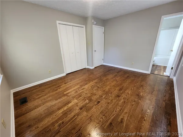 a view of empty room with wooden floor