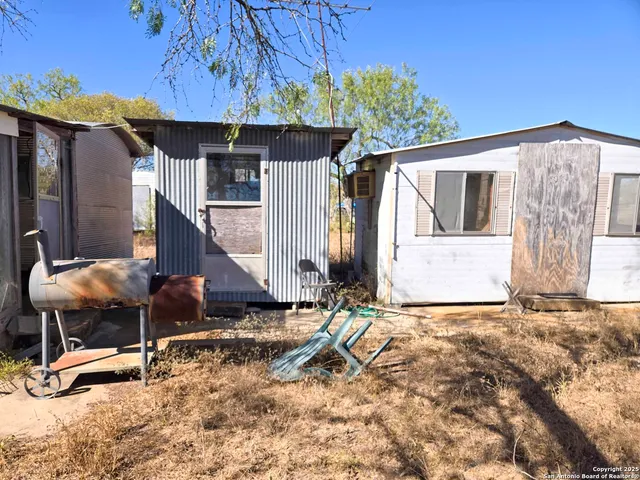 a backyard of a house with table and chairs