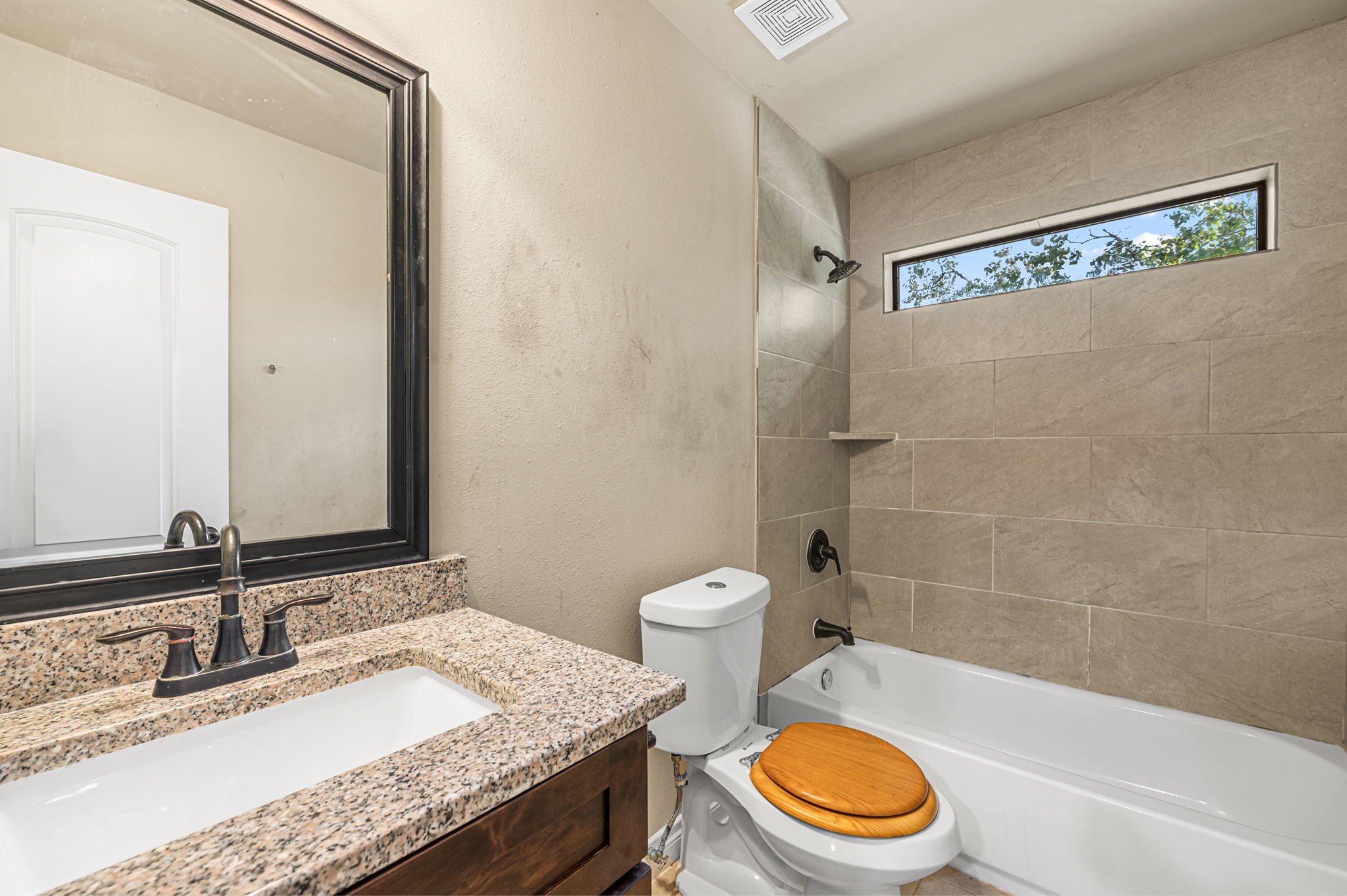 6838 Foster Street Houston, TX 77021 - Photo 21 of 24 Full secondary bathroom featuring a granite vanity and tiled tub-and-shower combination