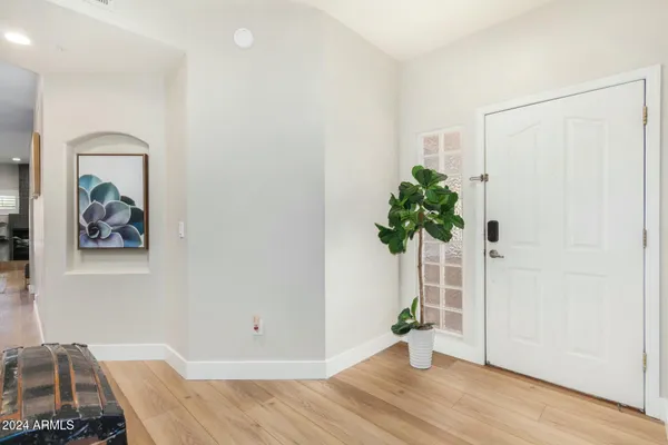 a view of a hallway with wooden floor and a potted plant