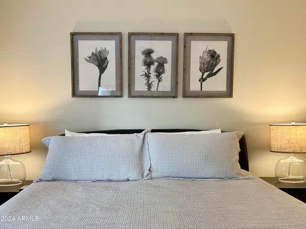 a bed room with a large bed and a painting on the wall