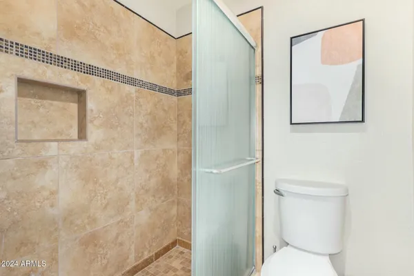 a bathroom with a toilet and a shower