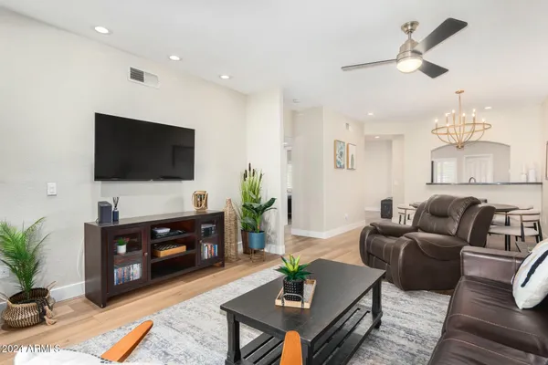 a living room with furniture a flat screen tv and a dining table