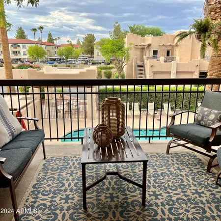 a balcony with a couch and large trees