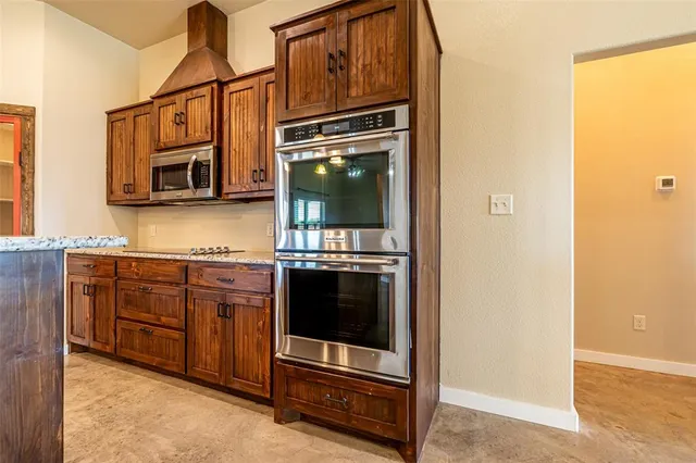a kitchen with granite countertop a sink cabinets and wooden floor