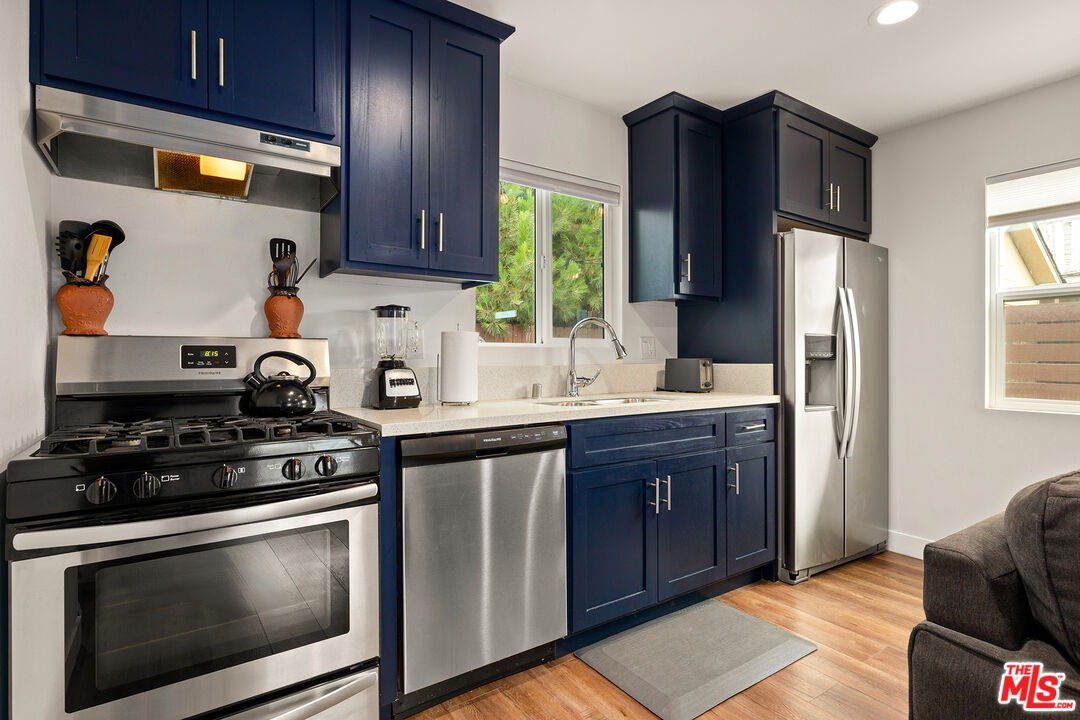 5325 9th Avenue, Unit 5327 Los Angeles, CA 90043 - Photo 5 of 11 a kitchen with stainless steel appliances wooden cabinets and a stove top oven