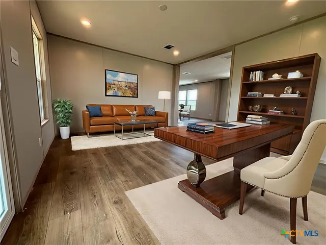 a living room with furniture and wooden floor