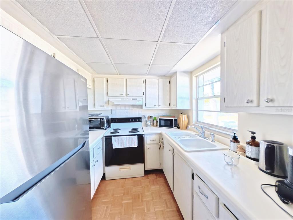102 47th Ave Drive West, Unit 342 Bradenton, FL 34207 - Photo 10 of 20 a kitchen with a sink a refrigerator and window