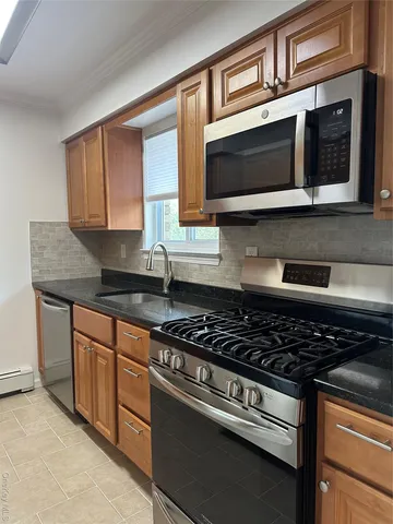 a kitchen with stainless steel appliances granite countertop a stove microwave and sink