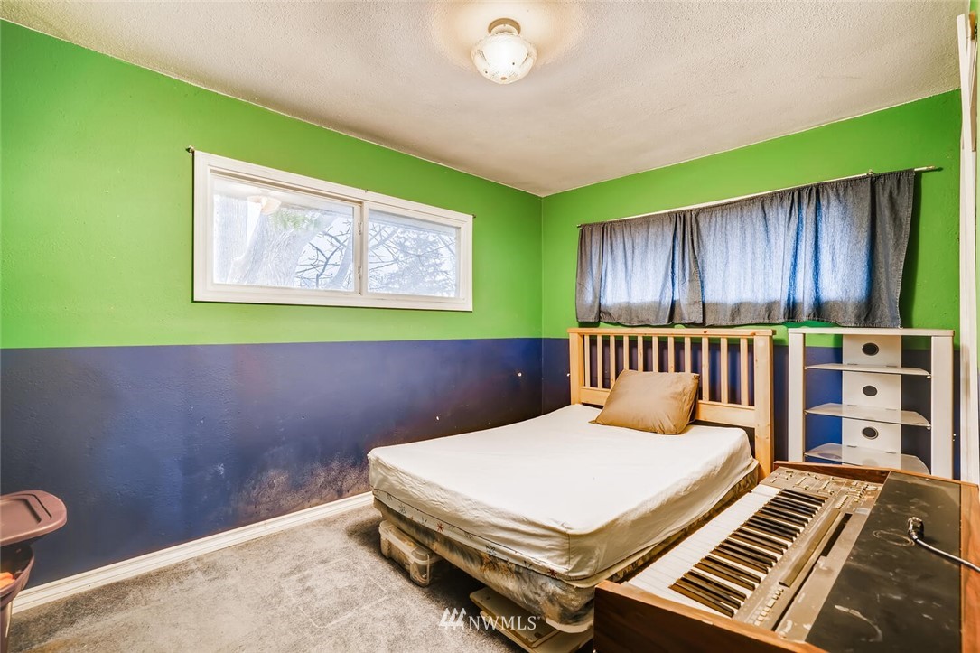 11526 Southeast Petrovitsky Road Renton, WA 98055 - Photo 16 of 28 a bedroom with a bed and a bookshelf with wooden walls