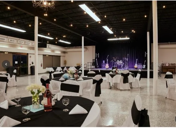 a living room with stainless steel appliances wooden floor and large window