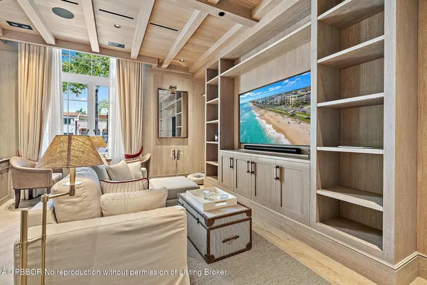 a living room with furniture a flat screen tv and a floor to ceiling window