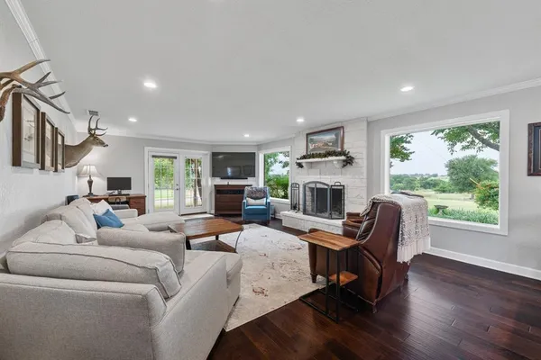 a living room with furniture a fireplace and a large window