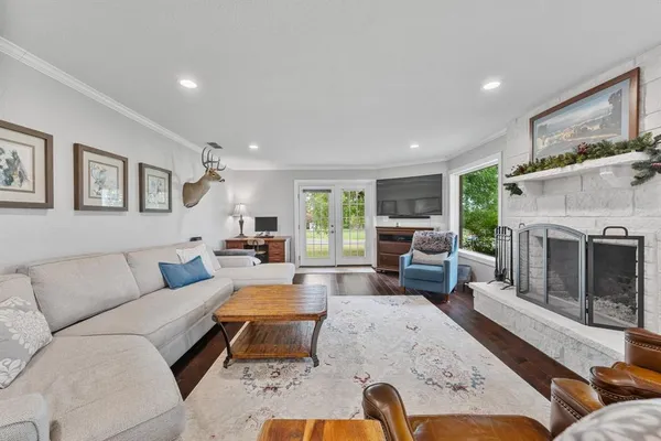a living room with furniture large window and a fireplace