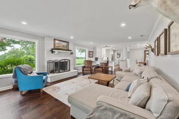 a living room with furniture fireplace and a large window
