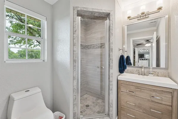a bathroom with a sink a toilet and shower