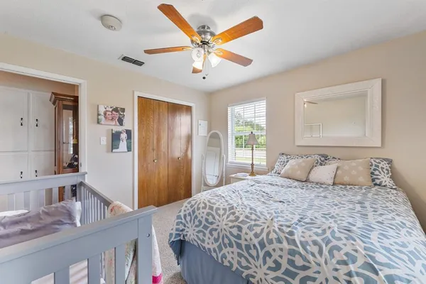 a bedroom with a large bed and a chandelier