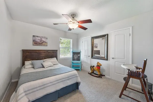 a bedroom with furniture and a ceiling fan