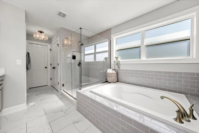 a spacious bathroom with a tub shower and sink