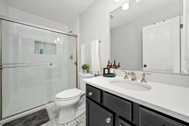 a bathroom with a sink a toilet and shower