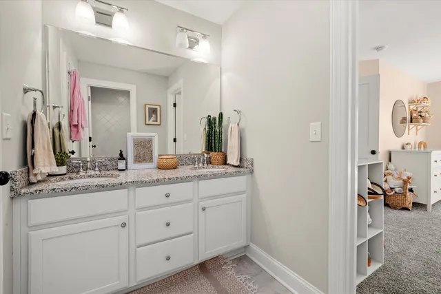 a en suite bathroom with a granite countertop sink and a mirror