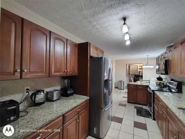a kitchen with stainless steel appliances granite countertop a refrigerator and a sink