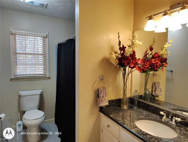 a bathroom with a granite countertop sink a mirror and a shower