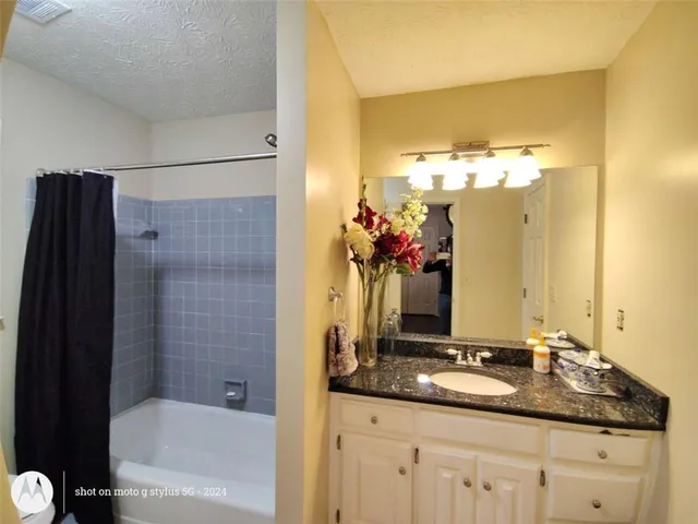a bathroom with a mirror a double vanity sink and glass door shower