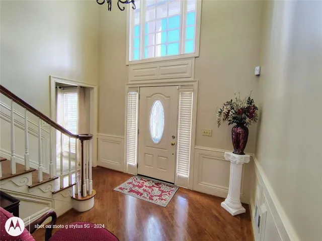 a view of staircase with lots of frames on wall and wooden floor