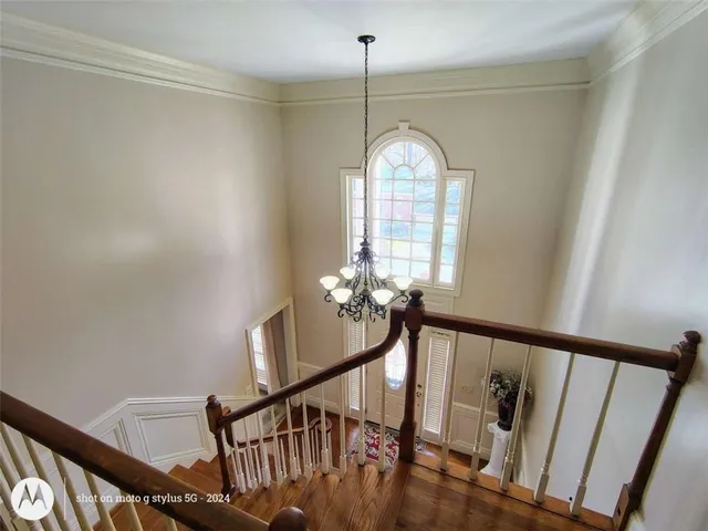 a view of a hallway with entryway wooden floor and stair