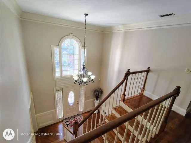 a view of a dining room and livingroom with furniture wooden floor a chandelier