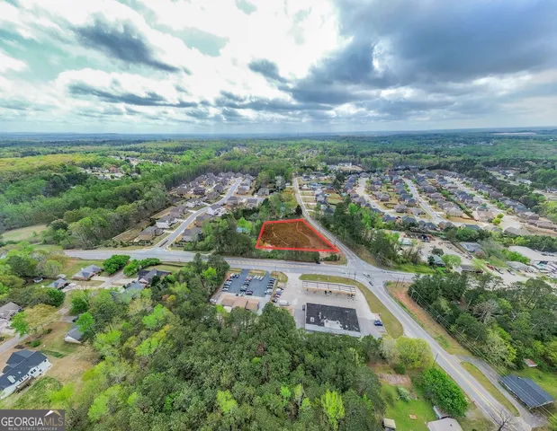 an aerial view of residential building with yard and mountain view in back
