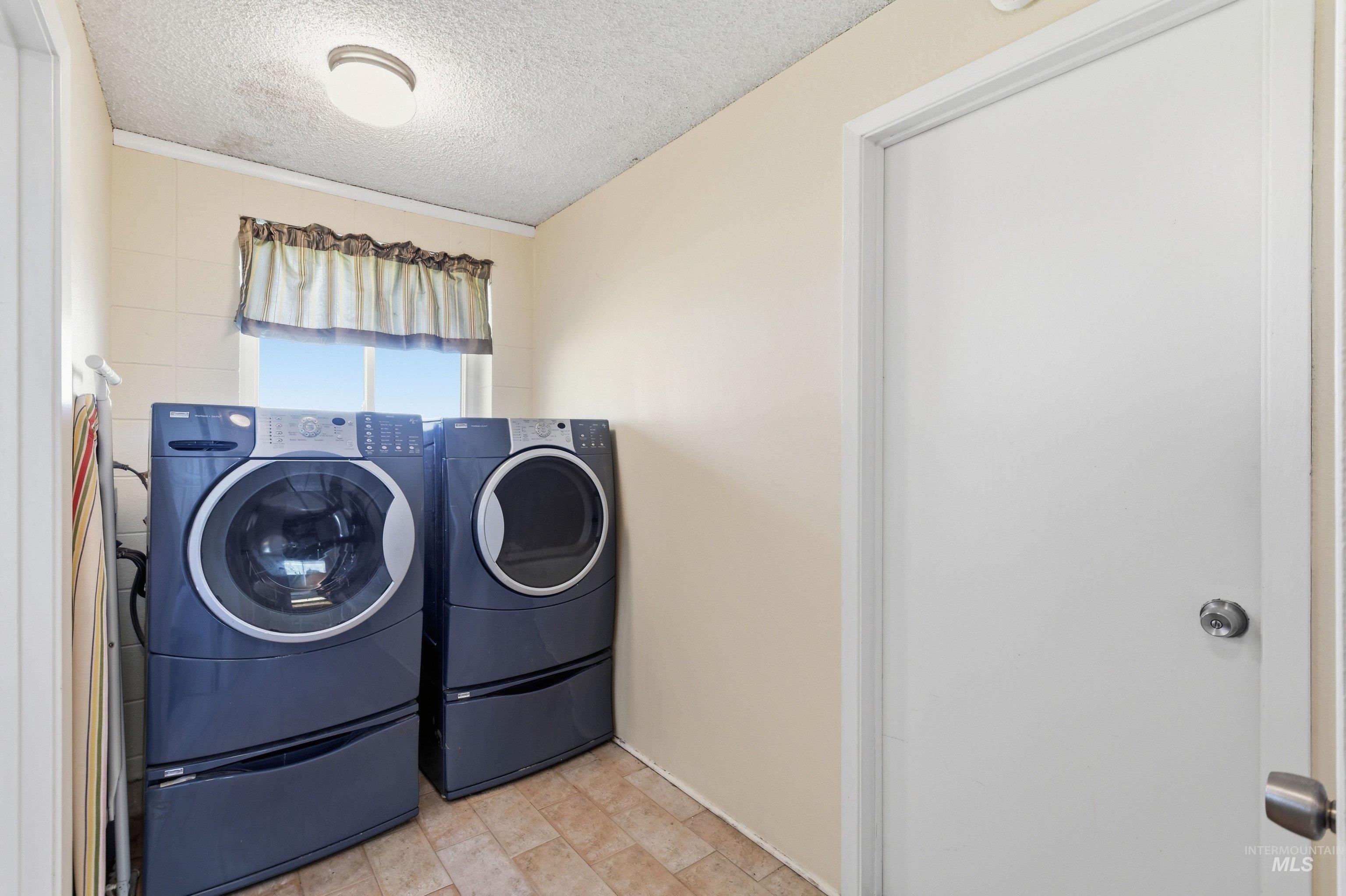 15095 David Street Caldwell, ID 83607 - Photo 26 of 39 Laundry area featuring tile flooring, a window, and a ceiling-mounted light fixture