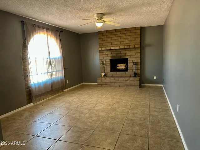an empty room with windows and fireplace