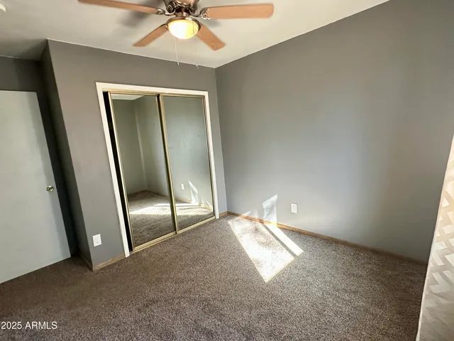 an empty room with a mirror and fan