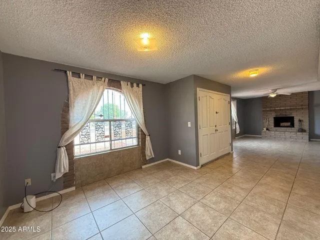 an empty room with windows and fireplace