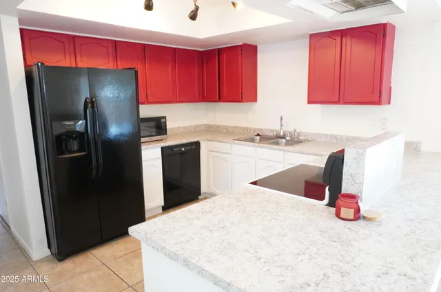 a kitchen with a refrigerator sink and cabinets