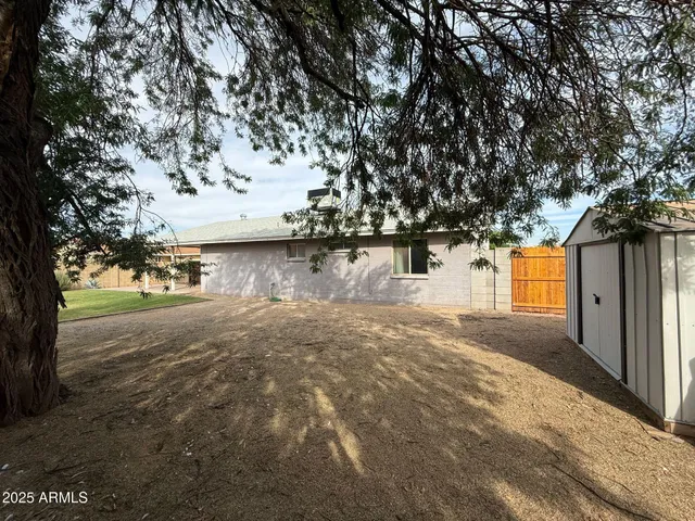 a view of a yard with wooden fence and a bench