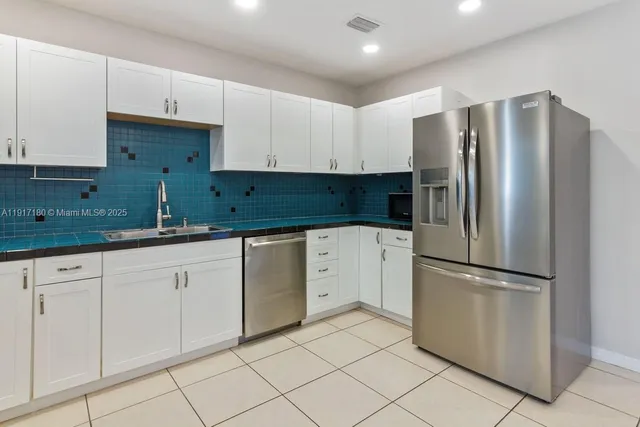 a kitchen with cabinets and stainless steel appliances