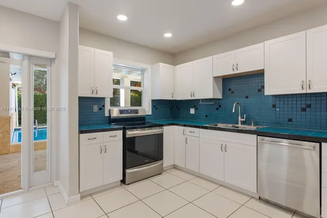 a kitchen with granite countertop white cabinets and white appliances