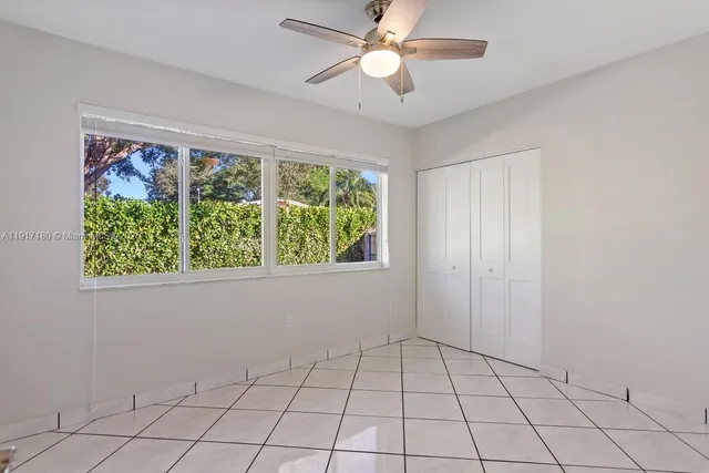 a view of an empty room with window chandelier fan